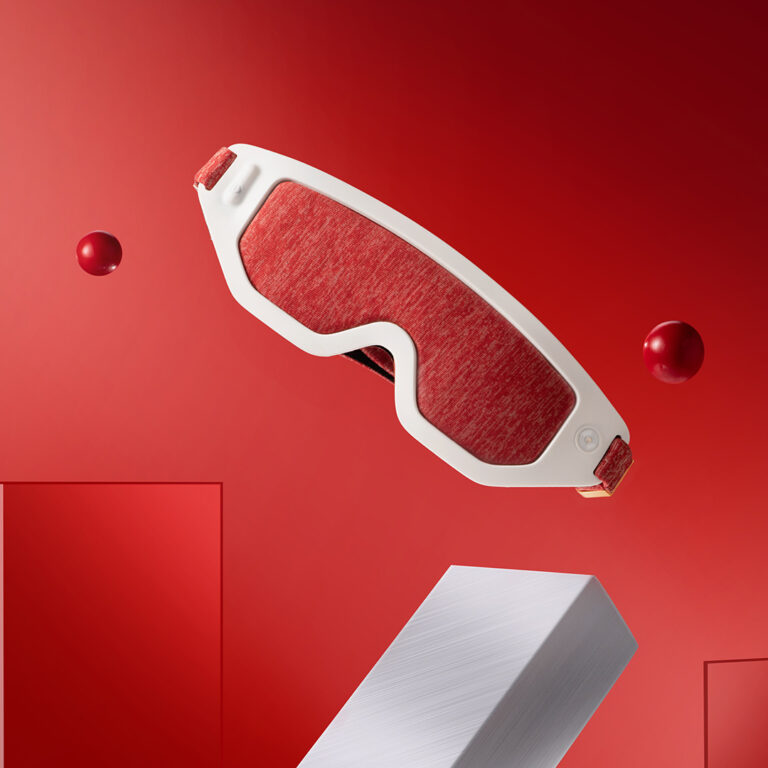 F30 Graphene Heated Sleep Eye Mask: red mask on a red display background.