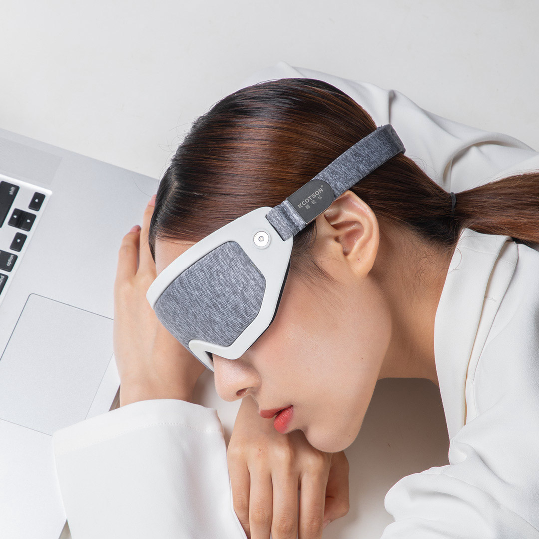 F30 Graphene Heated Sleep Eye Mask: gray mask used during a desk rest.