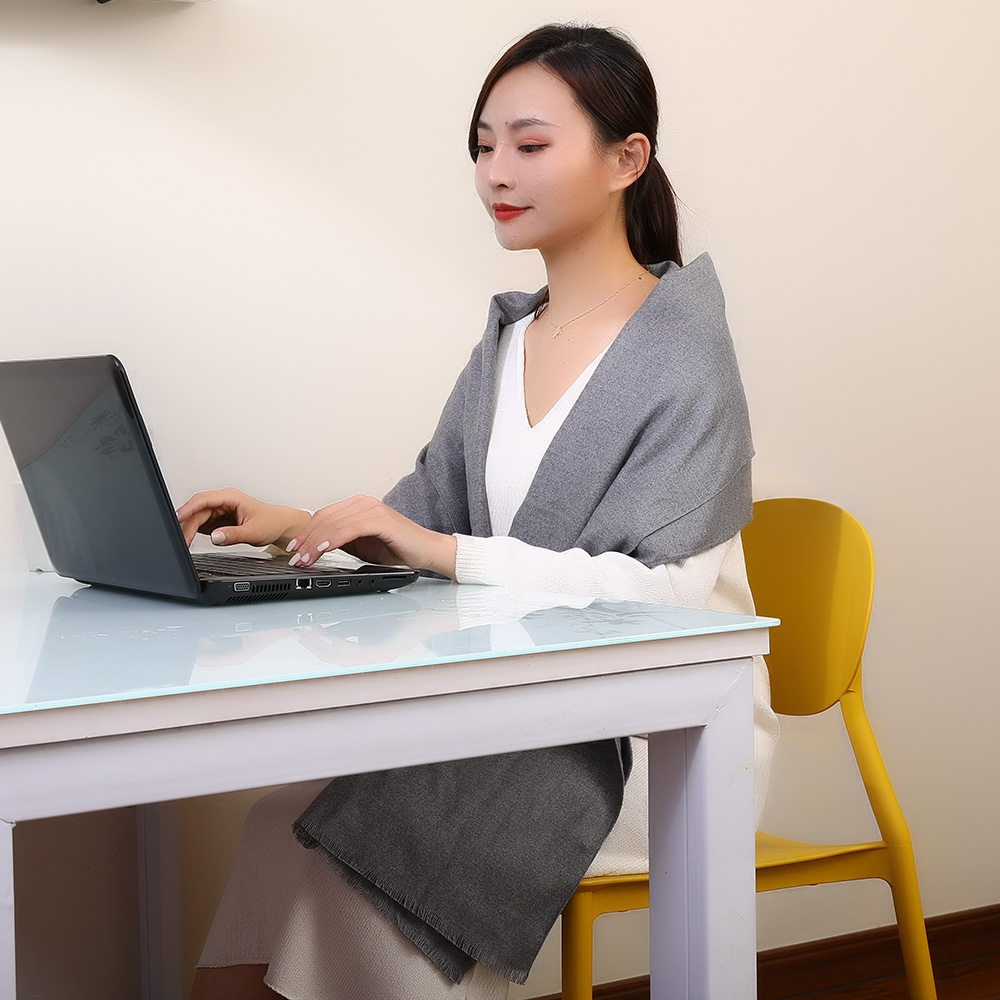 R10 Graphene Heated Scarf: woman wearing the scarf at a laptop desk.