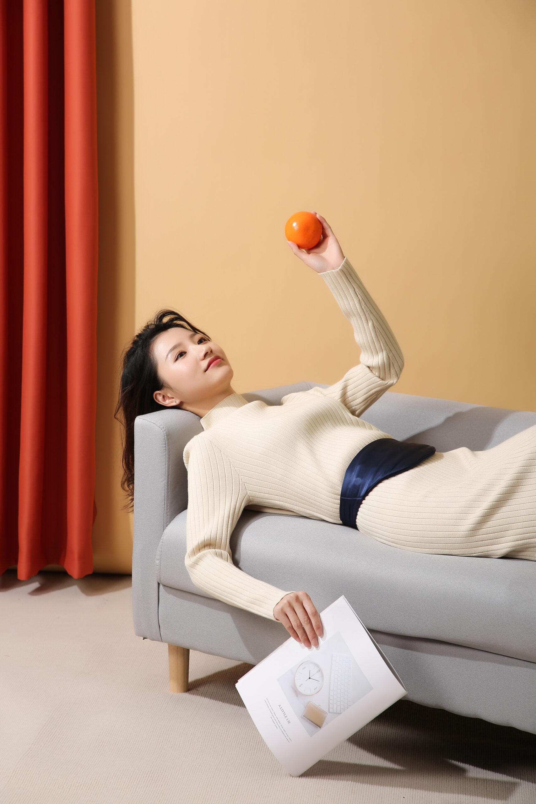 D10 Graphene Heated Silk Abdomen Belt: woman reclining on a sofa with the blue abdomen belt.