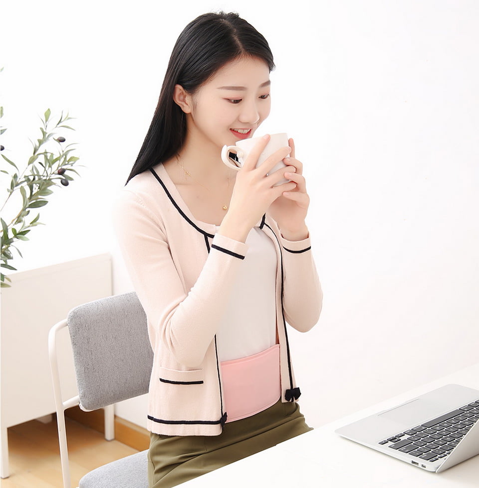 S20 Graphene Heated Abdomen Belt: woman wearing the belt at a laptop desk.