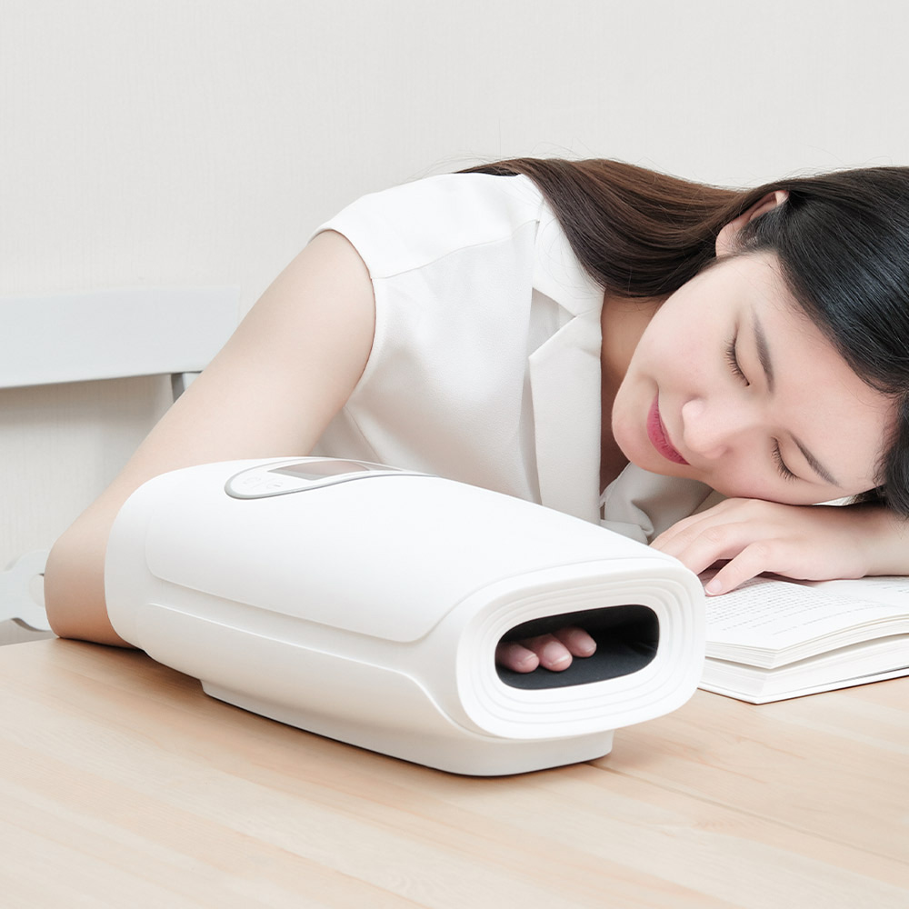 C20 Graphene Heated Hand Massager: woman resting with her hand inside the device.