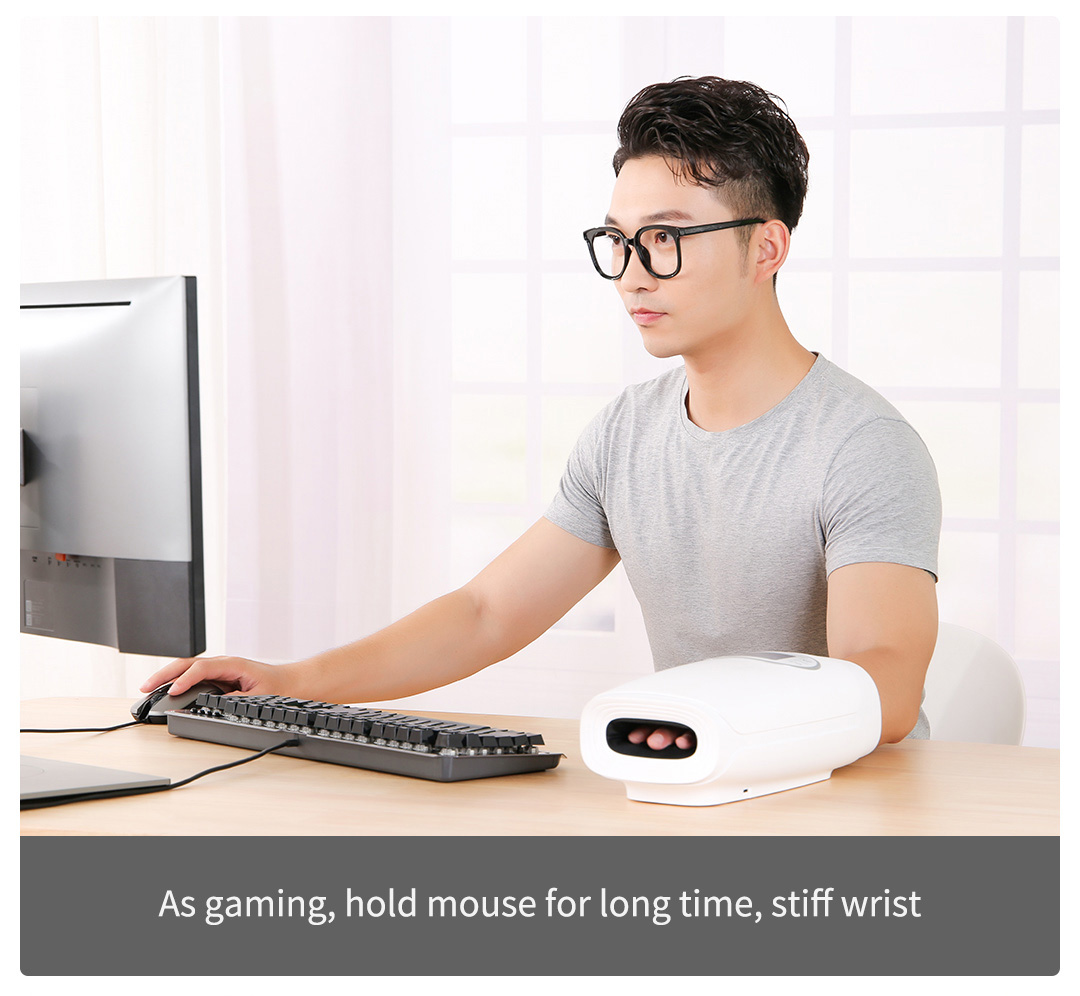 C20 Graphene Heated Hand Massager: man using the massager at a desktop workstation.