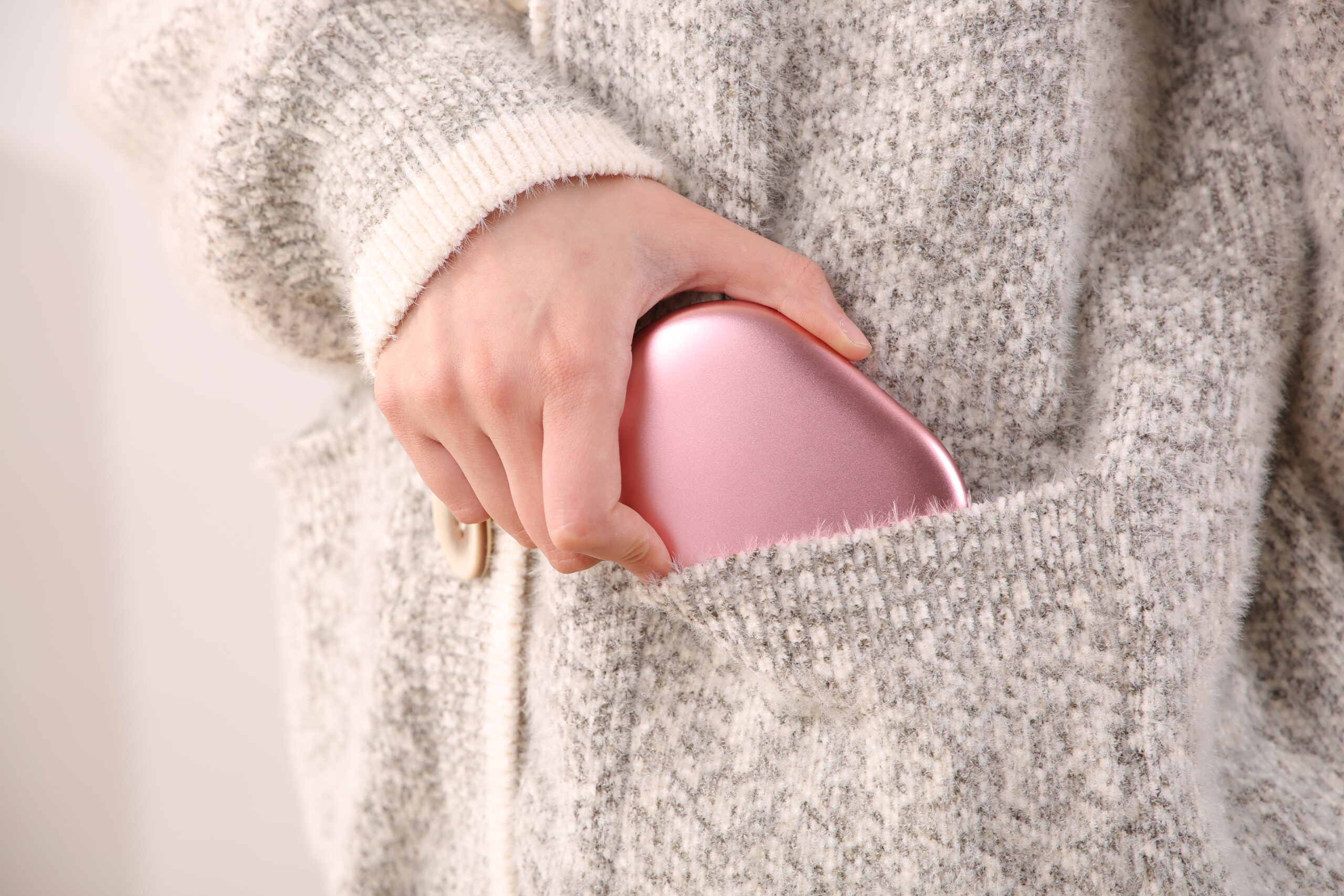 Z20 Graphene Heated Hand Warmer: pink hand warmer inside a cardigan pocket.