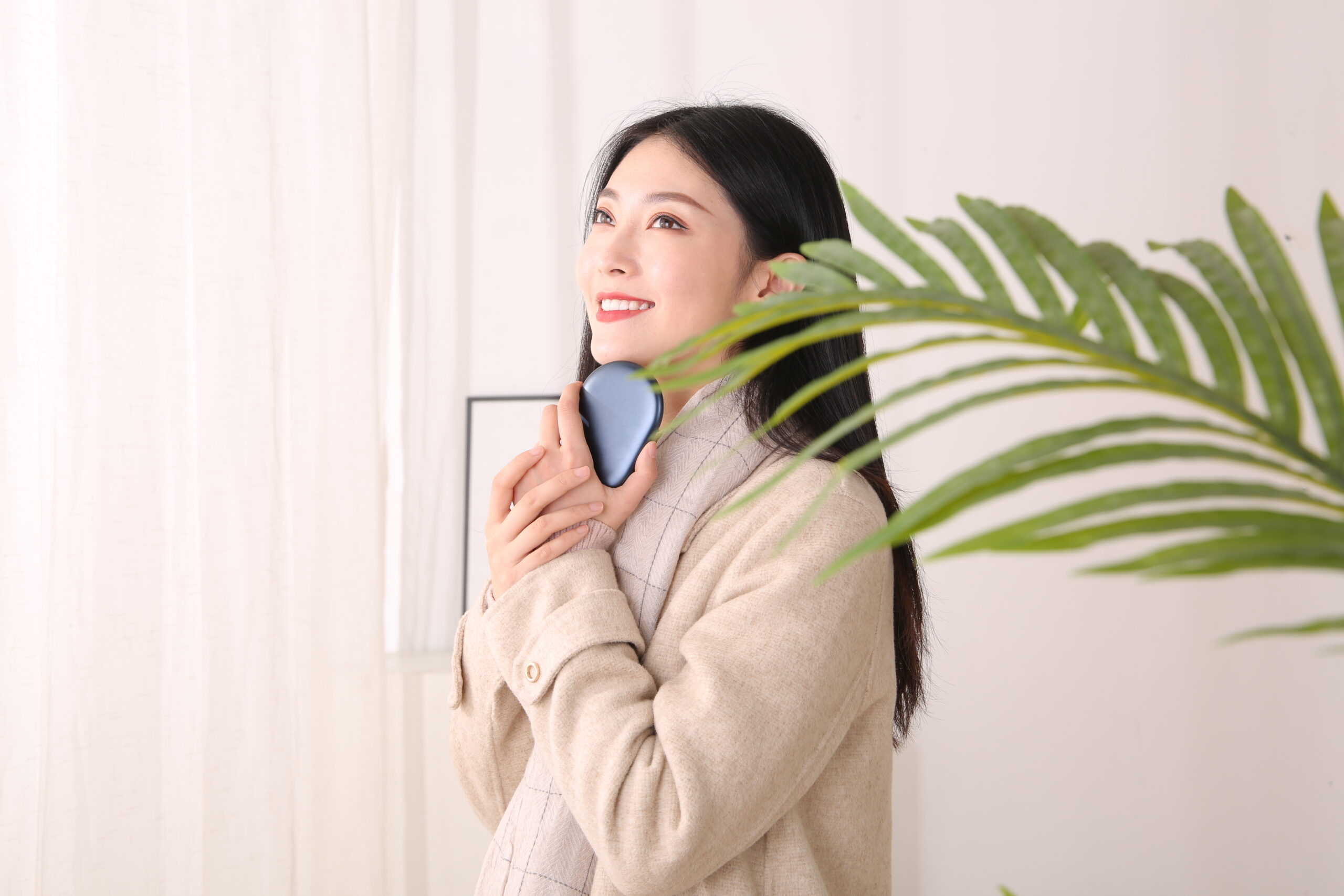 Z20 Graphene Heated Hand Warmer: woman holding the blue warmer indoors.