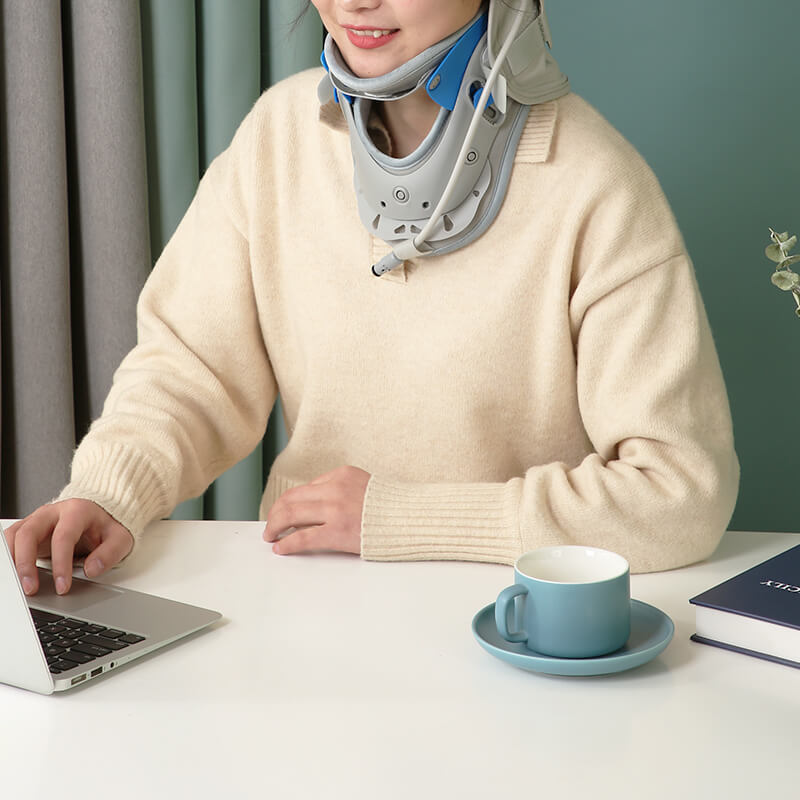 Woman using a laptop while wearing the cervical neck brace