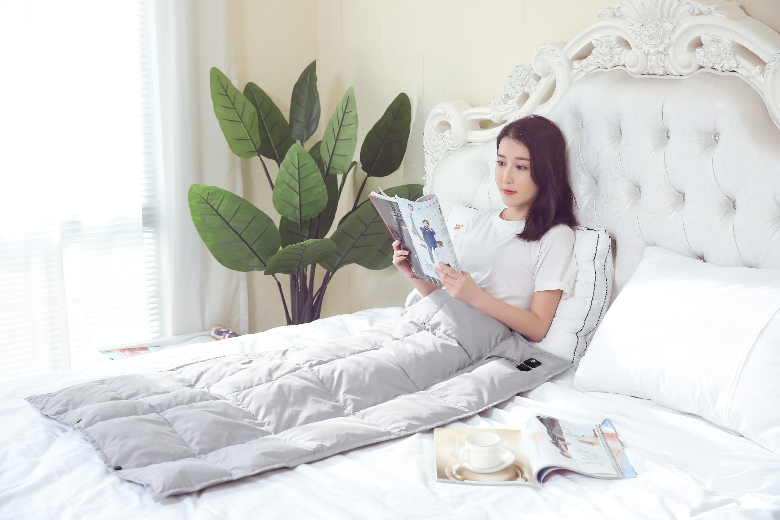 B20 Graphene Heated Down Blanket: gray blanket used while reading in bed.