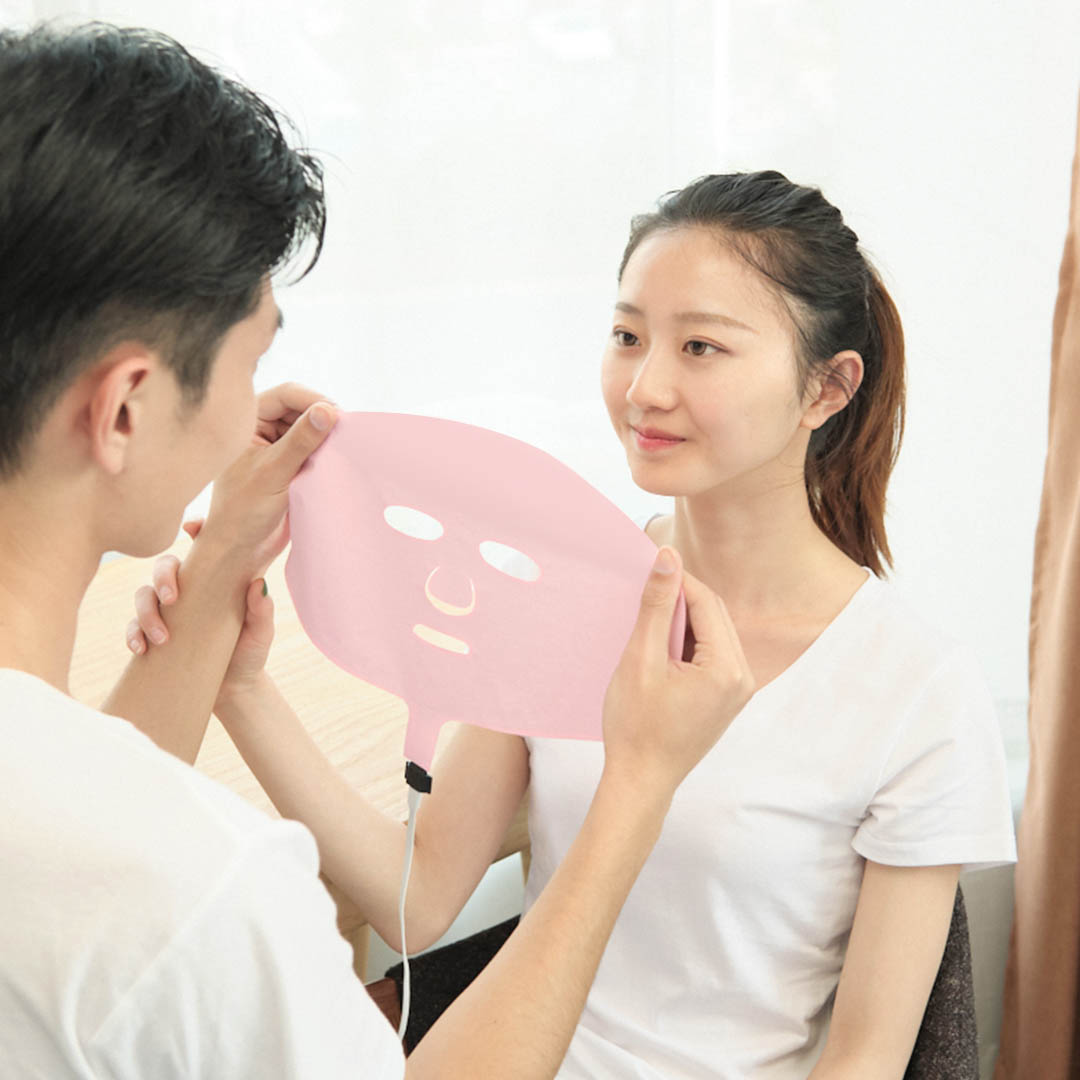 X10 Graphene Heated Face Mask: couple handling the pink mask.