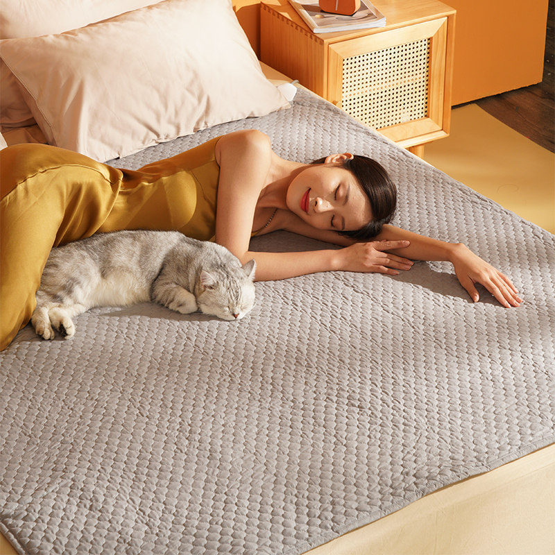 Graphene Heated Mattress Pad: woman resting on the pad beside a cat.