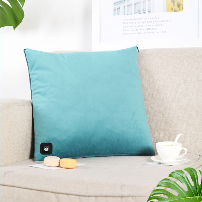Teal graphene heated pillow displayed on a sofa