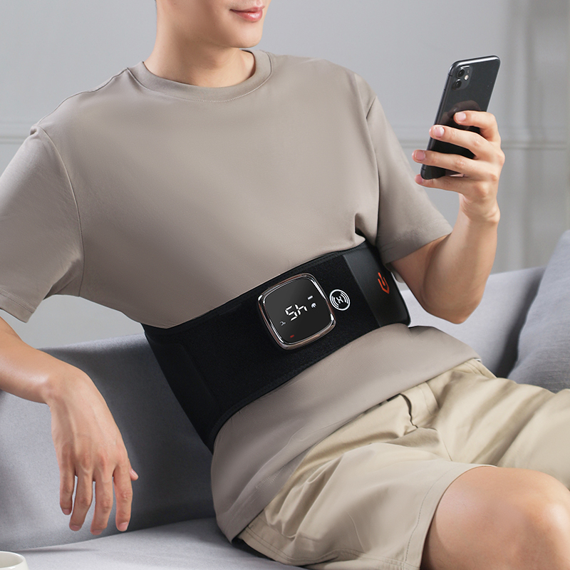 Graphene Heated Massage Belt: reclining use with digital controller visible.