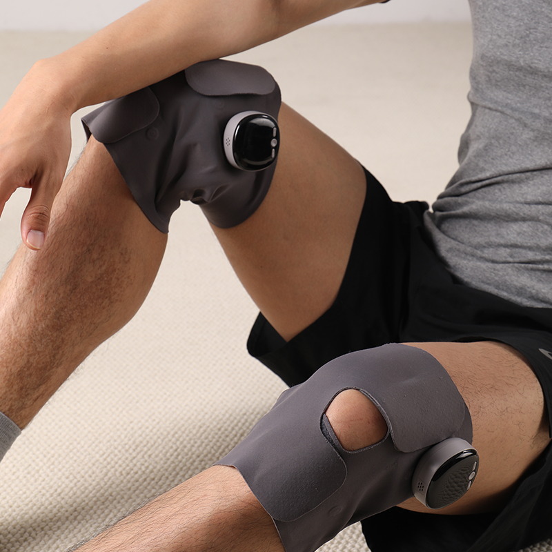 EMS Lightweight Knee Brace: man wearing a pair of braces while seated.