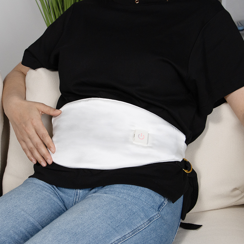 Graphene heated silk abdominal warmer worn while seated